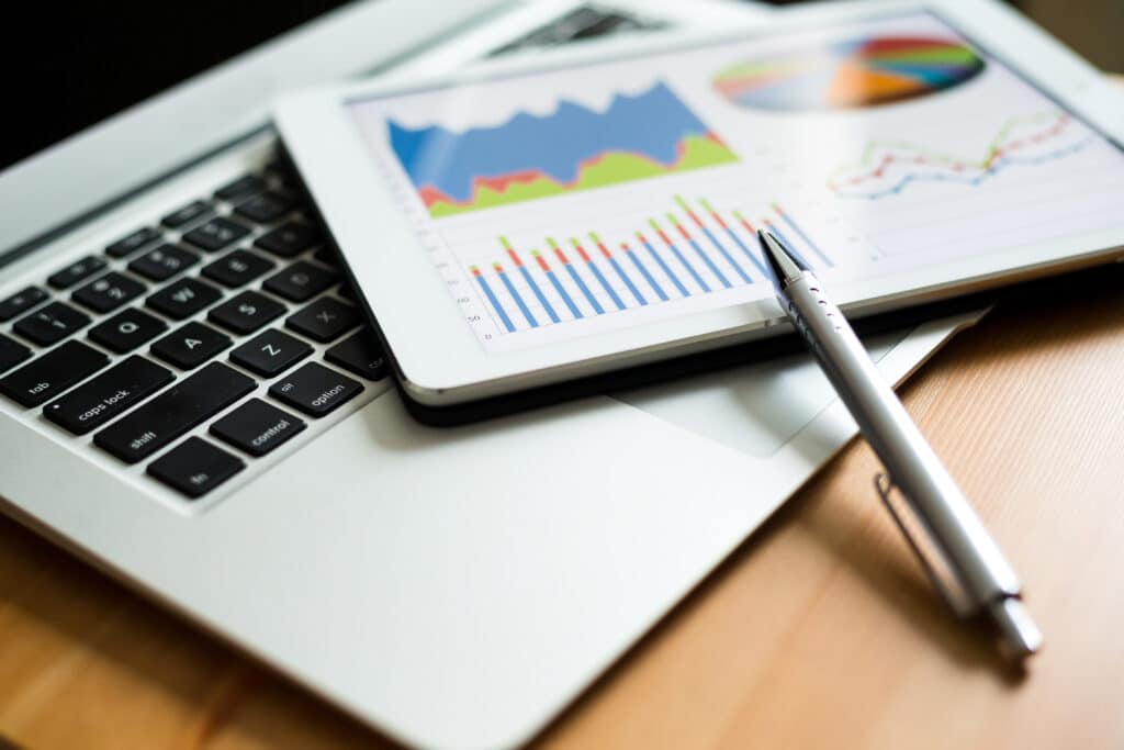 laptop with notebook showing analytics on top of it. a pen rests precariously on the noteboook - Supercharge your retargeting campaigns and win back your potential customers! Dive into this dynamic guide, exploring key performance metrics, including Click-Through Rate, Conversion Rate, Cost per Conversion, and Retargeting Reach. Get ready to craft compelling campaigns that resonate with your audience and drive business growth. - What metrics should be tracked to measure the success of retargeting campaigns? - your wp guy