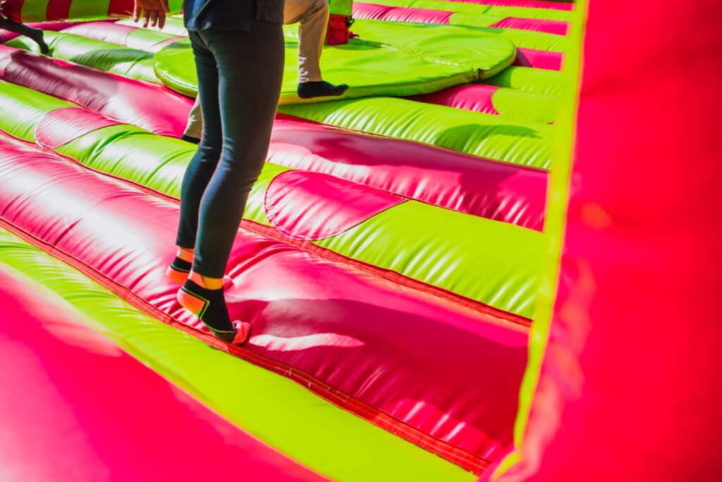 Legs of girl jumping with energy is a bouncing castle.